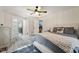 Bedroom with open doorways to bathroom and closet featuring soft blue and grey decor, and light wood flooring at 10614 Hudson Ave, Hudson, FL 34669