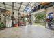 View of a spacious garage with tools, a bicycle, and an open door to the outside at 10614 Hudson Ave, Hudson, FL 34669