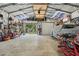 Spacious garage featuring a covered car, tools, and open door to the outside at 10614 Hudson Ave, Hudson, FL 34669