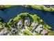 Aerial view of homes situated along a peaceful lake, surrounded by lush greenery and mature trees at 10751 Tavistock Dr, Tampa, FL 33626