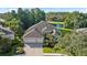 Aerial view of a beautiful home with a three-car garage, lush landscaping, and a serene water view at 10751 Tavistock Dr, Tampa, FL 33626