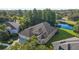 Aerial view of a beautiful home with a three-car garage, lush landscaping, and a serene water view at 10751 Tavistock Dr, Tampa, FL 33626