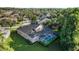 Aerial view of home with a screened-in pool and spa, situated in a neighborhood with mature trees at 10751 Tavistock Dr, Tampa, FL 33626