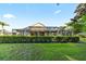 Expansive backyard featuring a lush green lawn, a screened-in patio, and meticulously maintained landscaping at 10751 Tavistock Dr, Tampa, FL 33626