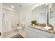 Bright bathroom featuring a granite countertop, cream cabinets, shower-tub combo, and a neutral color palette at 10751 Tavistock Dr, Tampa, FL 33626