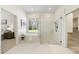 Well-lit bathroom showcasing soaking tub, glass-enclosed shower, and white hexagonal tile floor at 10751 Tavistock Dr, Tampa, FL 33626