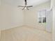 A bright, neutral bedroom with a ceiling fan and a window with plantation shutters at 10751 Tavistock Dr, Tampa, FL 33626