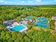 Aerial view of community amenities that include a pool, tennis courts, and recreational facilities surrounded by mature trees at 10751 Tavistock Dr, Tampa, FL 33626