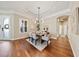Dining room with hardwood floors, elegant lighting, a decorative tray ceiling, and seating for six at 10751 Tavistock Dr, Tampa, FL 33626