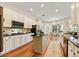 Bright kitchen featuring white cabinets, black countertops, and a center island with hardwood floors at 10751 Tavistock Dr, Tampa, FL 33626