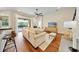 Bright living room features hardwood floors, ceiling fan, neutral paint, and sliding glass doors to outdoor pool at 10751 Tavistock Dr, Tampa, FL 33626