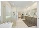 Bright main bathroom boasts a soaking tub, glass shower, dual sinks, and walk-in closet at 10751 Tavistock Dr, Tampa, FL 33626