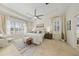 Bright main bedroom boasts tray ceiling, a ceiling fan, and large windows letting in natural light at 10751 Tavistock Dr, Tampa, FL 33626
