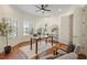 Inviting office featuring bay windows with shutters, hardwood floors, and a ceiling fan at 10751 Tavistock Dr, Tampa, FL 33626