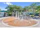 Community splash pad with multiple spouts in a round bricked area with trees and a blue building in the background on a sunny day at 10751 Tavistock Dr, Tampa, FL 33626
