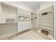 Spacious walk-in closet features white shelving and drawers providing ample storage space at 10751 Tavistock Dr, Tampa, FL 33626
