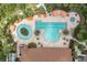 Aerial view of pool area with large pool, lazy river, umbrellas and lounge seating at 11039 Calluna Dr, Odessa, FL 33556