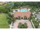 Aerial view of the clubhouse, pool, and surrounding amenities with lush landscaping and trees at 11039 Calluna Dr, Odessa, FL 33556