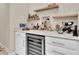Home bar featuring a wine refrigerator, storage cabinets, and display shelves at 11039 Calluna Dr, Odessa, FL 33556