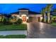 Charming home exterior featuring a paver driveway, lush landscaping, and a two-car garage at 11039 Calluna Dr, Odessa, FL 33556