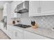 Gourmet kitchen featuring stainless steel vent hood, gas cooktop, and quartz countertops at 11039 Calluna Dr, Odessa, FL 33556