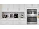 Close-up of the kitchen featuring stainless steel appliances and white cabinetry at 11039 Calluna Dr, Odessa, FL 33556