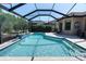 Refreshing pool area with a screened enclosure and lush tropical landscaping at 11039 Calluna Dr, Odessa, FL 33556