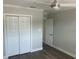 Bedroom with neutral walls, wood-look floors, and a double-door closet at 11110 1St E St, Treasure Island, FL 33706