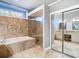 A luxurious bathroom featuring a soaking tub, glass shower, and vanity with double sinks at 11620 Eastern Star Ct, New Port Richey, FL 34654