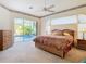 Bedroom featuring a bed, lamps, nightstands, ceiling fan, and a view of the pool at 11620 Eastern Star Ct, New Port Richey, FL 34654