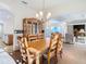 Elegant dining room with a chandelier, wood table and chairs, built-in hutch, and an open floor plan at 11620 Eastern Star Ct, New Port Richey, FL 34654