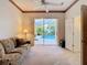 Cozy living room with a sliding door to pool, ceiling fan, and comfortable sofa in neutral colors at 11620 Eastern Star Ct, New Port Richey, FL 34654
