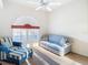 Bright sitting room with a cozy chair, couch, large window, and ceiling fan at 11620 Eastern Star Ct, New Port Richey, FL 34654