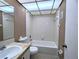 Bright bathroom features a shower-tub combo with white tile and a marble-look countertop sink at 11705 Raintree Village Blvd # C, Temple Terrace, FL 33617