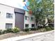 Exterior view of a condo building with well-maintained landscaping, reserved parking, and tree shade at 11705 Raintree Village Blvd # C, Temple Terrace, FL 33617