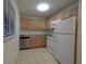 A compact kitchen features appliances, ample cabinet space and tiled flooring at 11705 Raintree Village Blvd # C, Temple Terrace, FL 33617