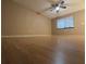An empty room with hardwood flooring, a ceiling fan and neutral paint at 11705 Raintree Village Blvd # C, Temple Terrace, FL 33617