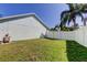 Side yard featuring a well-maintained lawn with a newer white vinyl fence creating a serene outdoor space at 12004 Plantain Ct, Tampa, FL 33635