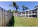 Beautiful backyard featuring lush grass, a wooden fence, and a screened-in pool area, perfect for relaxation at 12004 Plantain Ct, Tampa, FL 33635