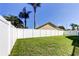 Spacious, green backyard featuring a white vinyl fence, mature trees, and lush grass, perfect for entertaining at 12004 Plantain Ct, Tampa, FL 33635