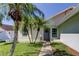Charming front entry with a grey door, potted palms and a well-manicured lawn at 12004 Plantain Ct, Tampa, FL 33635