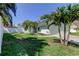 Well-maintained front yard with a white fence, palm trees, and a single-story home at 12004 Plantain Ct, Tampa, FL 33635