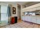 Efficient kitchen space with white cabinets, a window, and convenient access to adjacent rooms at 12004 Plantain Ct, Tampa, FL 33635