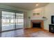 Bright living room with fireplace and sliding glass doors to the screened pool area at 12004 Plantain Ct, Tampa, FL 33635