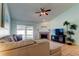 Cozy living room with a ceiling fan, fireplace, and sliding door access to the pool at 12004 Plantain Ct, Tampa, FL 33635