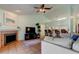 Inviting living room featuring a fireplace, ceiling fan, and open layout with kitchen access at 12004 Plantain Ct, Tampa, FL 33635