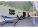 Covered patio with seating, a hanging hammock, and access to the backyard at 12004 Plantain Ct, Tampa, FL 33635