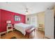 Bedroom with hardwood floors, a bed and red bench, and a small window with white curtains at 13238 Asbury St, Spring Hill, FL 34609
