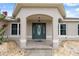 Inviting front entrance with decorative door, overhead lighting, and beautiful tiled entryway under an arched portico at 13238 Asbury St, Spring Hill, FL 34609