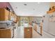 Eat-in kitchen featuring an island, white appliances, and natural lighting at 13238 Asbury St, Spring Hill, FL 34609